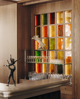 Château Royal part of the bar counter with stained glass, shelves with dishes and atmospheric figurines