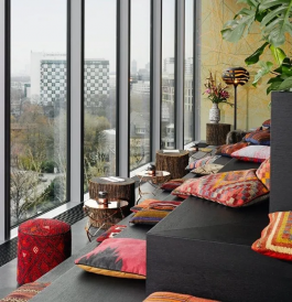 Monkey Bar seats with cushions and small tables facing large windows