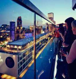 Monkey Bar people look out at the view of evening Berlin from the rooftop terrace