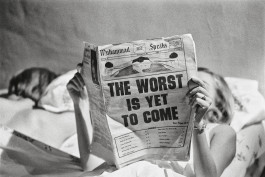 Camera Work exhibition, black and white photo of a woman lying on a bed reading a newspaper, the headline reads