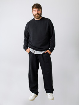 man posing in black sweatshirt and black sweatpants