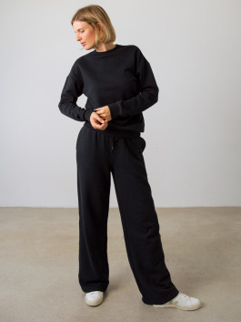 woman posing in black sweatshirt and black sweatpants 