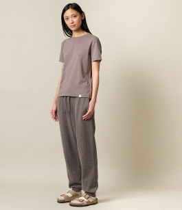woman posing in grey t-shirt, grey sweatpants and beige sandals