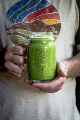 Person holding a jar of green smoothie