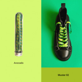 the background is divided into light green (left) and green (right), on the left is a tube with green shoe laces with an avocado print and the inscription