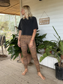 woman posing on terrace of house in black t-shirt and tiger leggings